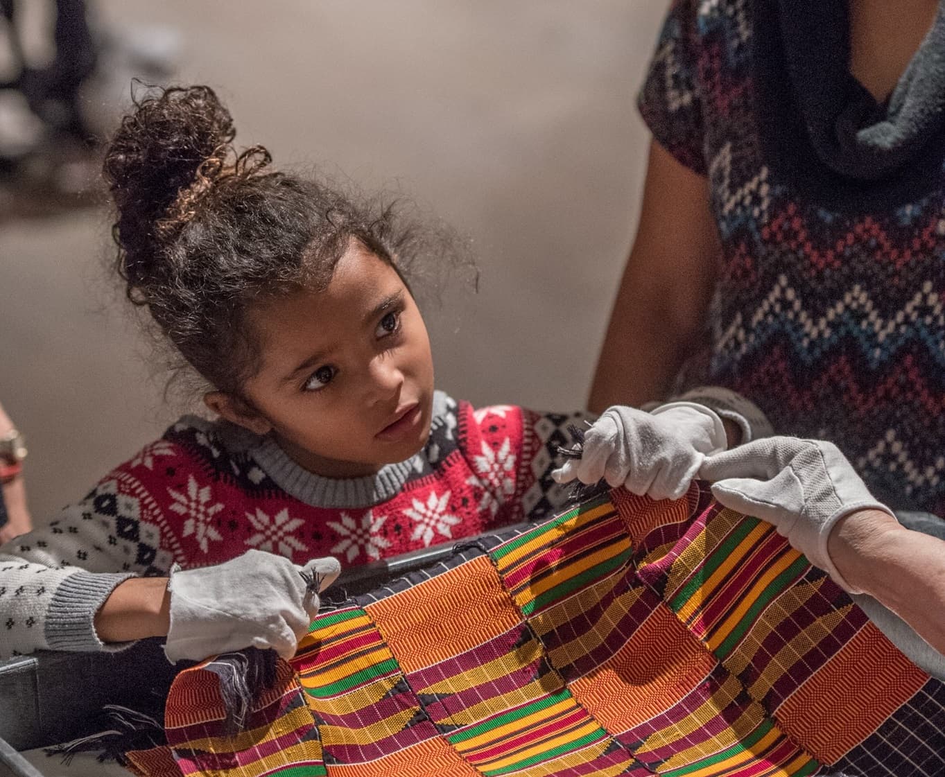 Young girl touching a textile with gloves